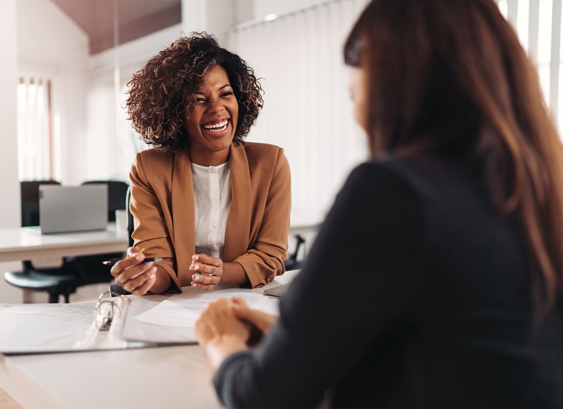 About Our Agency - Young Woman Meeting an Employee For a Meeting at the Office